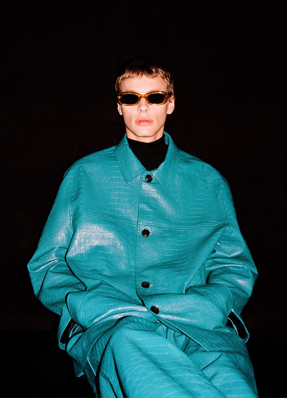 A male model in a blue suits for an eyewear brand's campaign