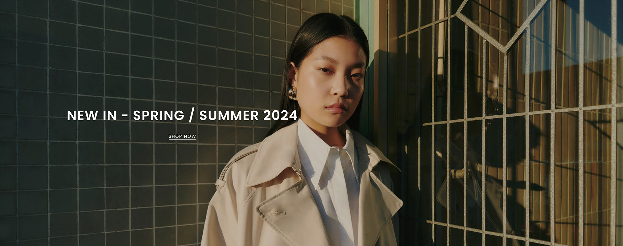 An Asian woman striking a pose in front of raw studios. for their SS24 campaign