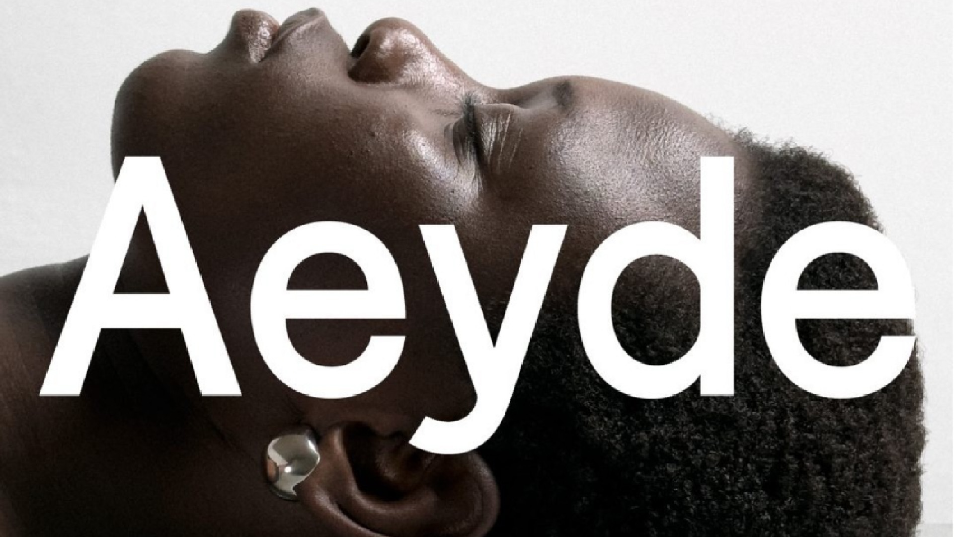 Close-up of Ajah Angau’s face in profile with silver earrings, eyes closed in a serene expression – part of the Sleeping Beauty campaign shot at raw studios.