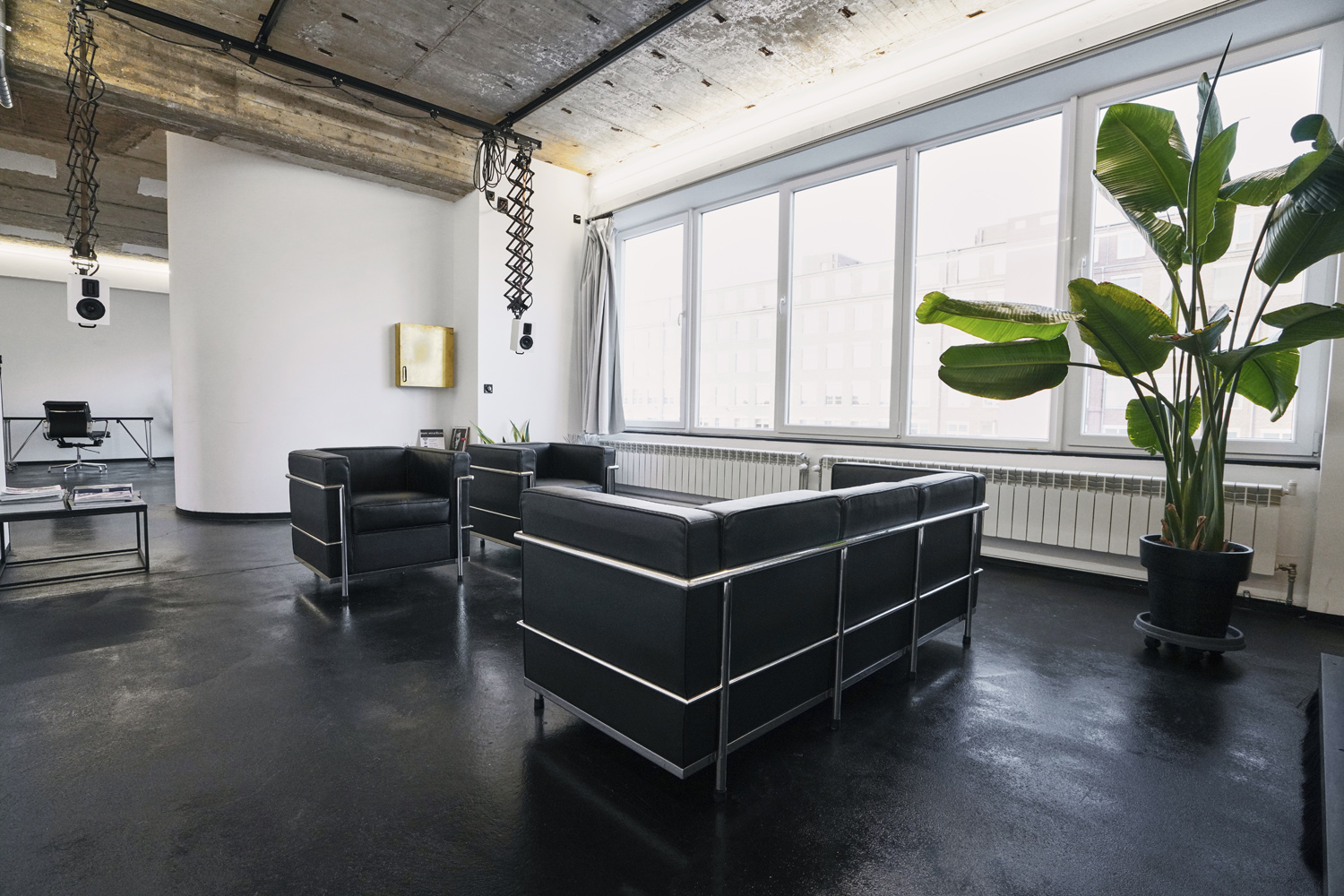 raw_studios_studio3_loungearea4_DE Kundenbereich in Studio 3, einem Mietstudio für Foto- und Videoproduktionen in Berlin, ausgestattet mit Sesseln, Deckenlautsprechern und Tageslicht