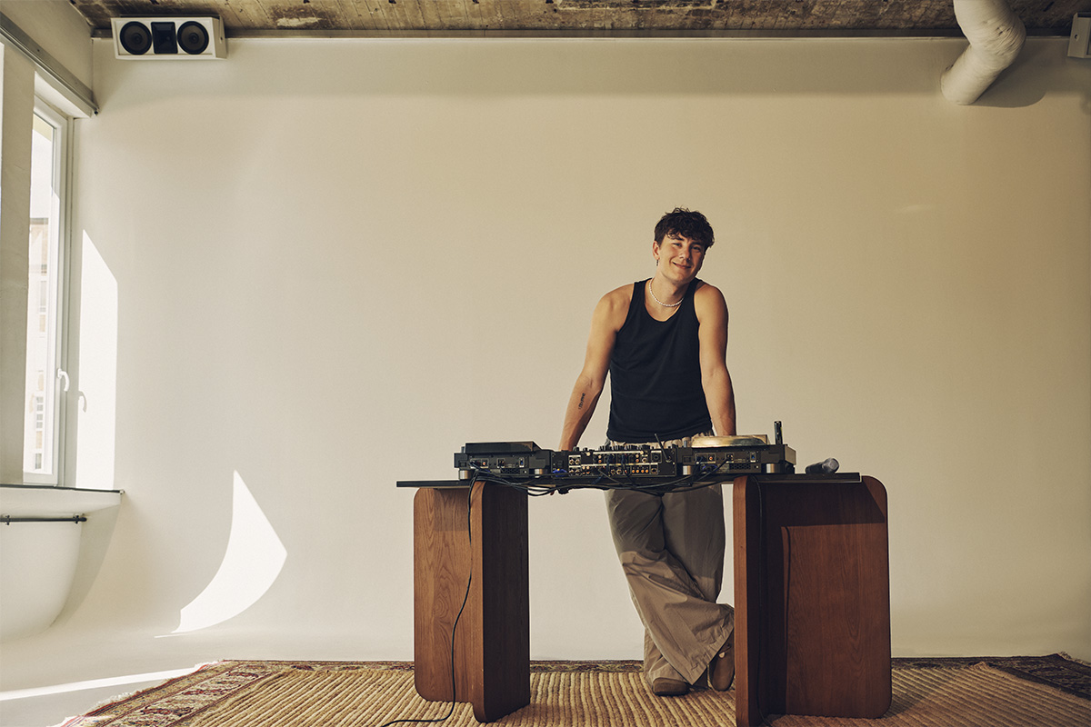 DJ BUNT. at raw studios in Berlin, leaning against his DJ setup in daylight-filled Studio 1, showcasing the minimal, versatile space of a rental studio berlin perfect for music and film shoots.