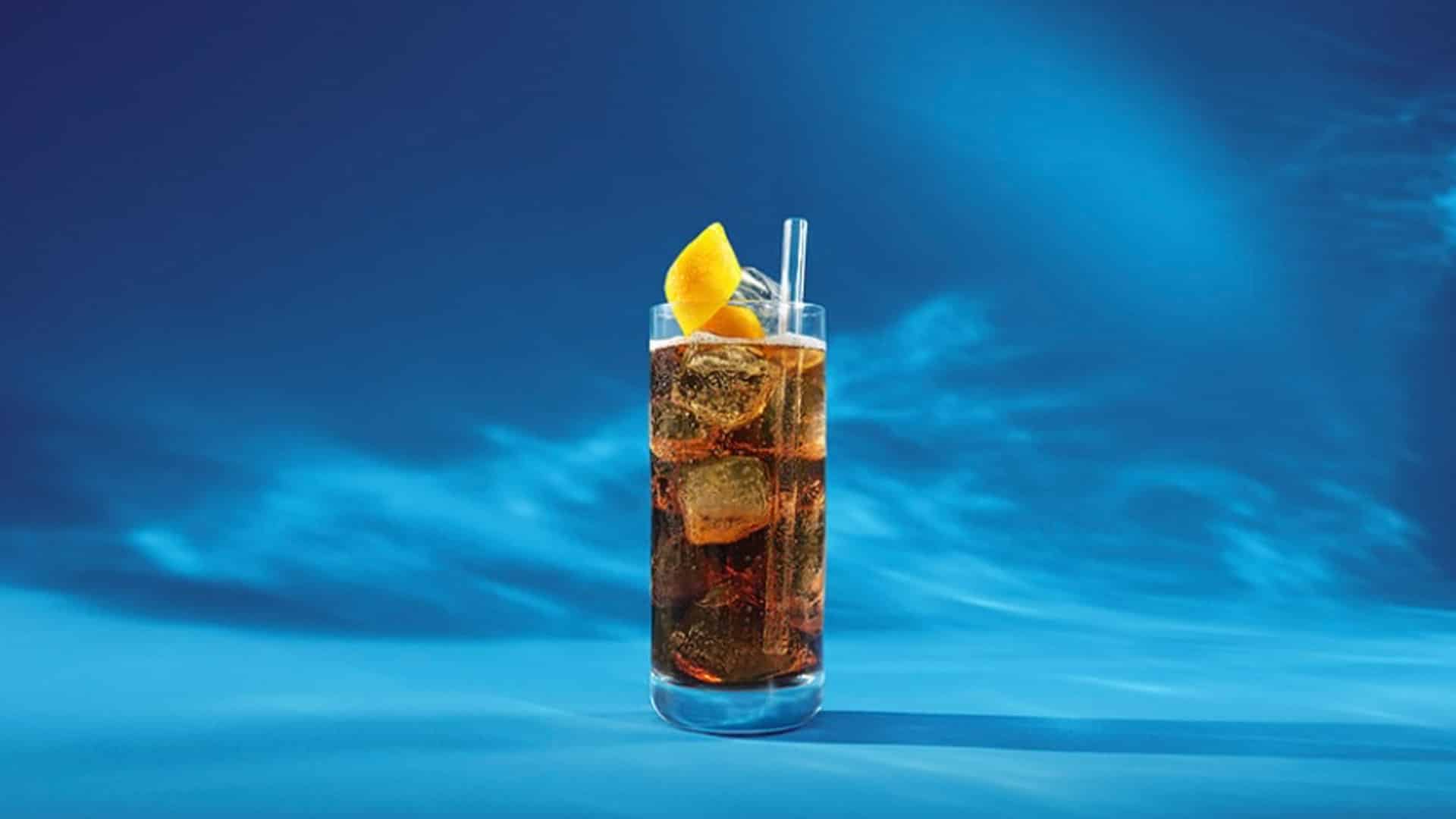Glass of cola with lemon slice photographed on blue background during ALDI Nord ‘Teuer? Nee, ALDI.’ campaign at raw studios Berlin.